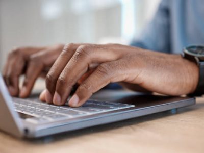 Office, hands typing on laptop and man at desk at law firm writing email or message on legal advice. Tech, communication and networking, lawyer at computer keyboard for research on government website